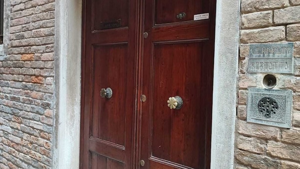 Una puerta doble de madera con una placa que dice "GERARDINI BERTATTA" y el número "2282A" encima.