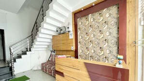 Un moderno vestíbulo de hotel con una escalera, un mostrador de recepción y un muro con diseño.