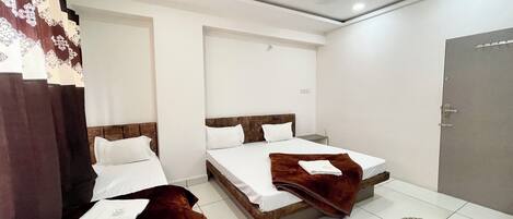 A hotel room with two beds, a ceiling fan, and a door.