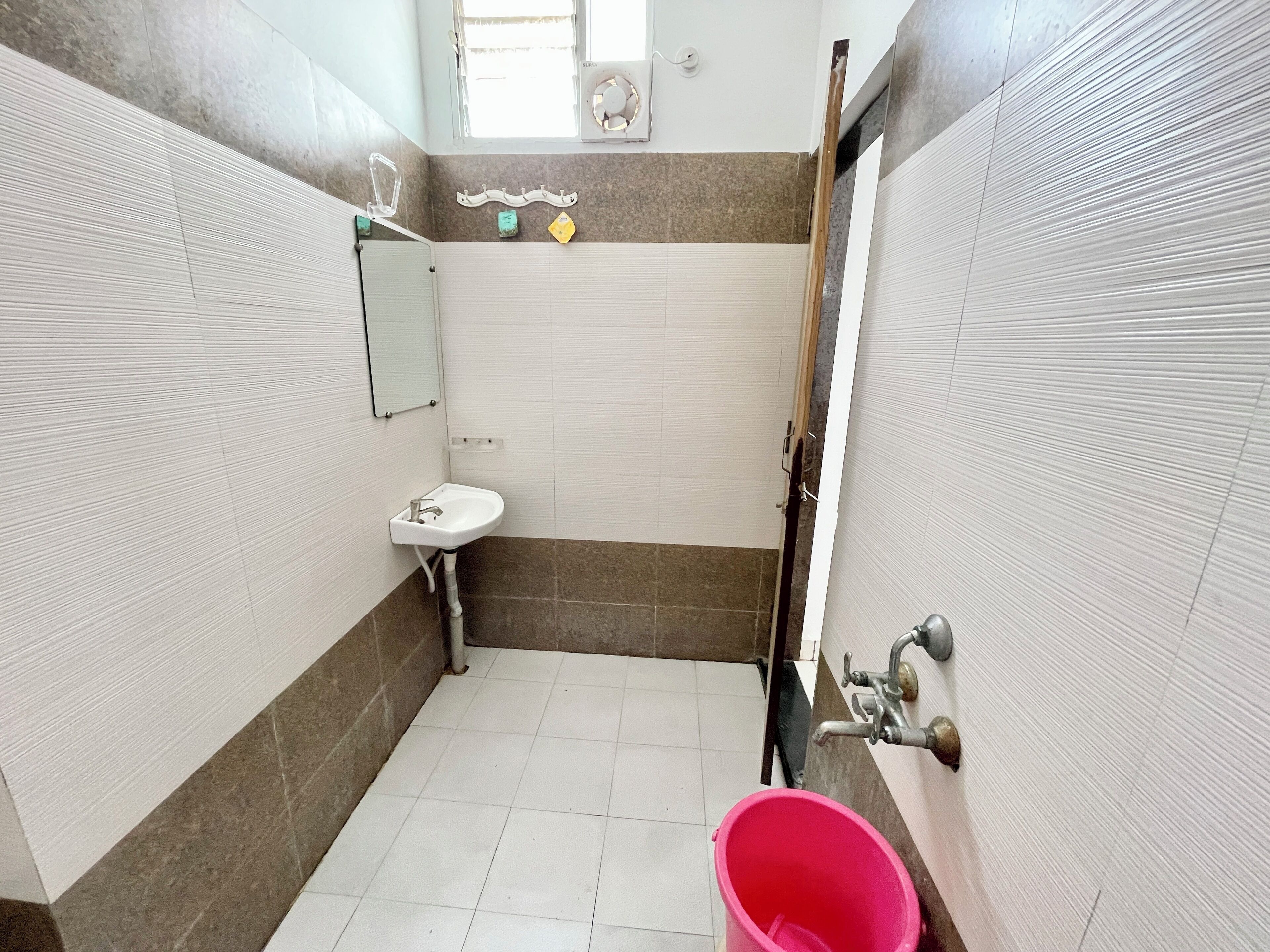 A small bathroom with a sink, mirror, and a shower area.