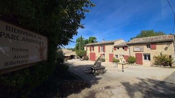 A sign for a park animal center with directions to parking, reception, and ticket office.