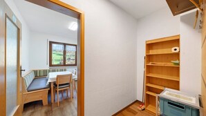 Een kamer met een houten bank, een tafel en een raam.