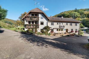 A two-story building with a balcony, a small garden, and a clear sky. - Apartment 'No. 2.1 Rotkelchen' with Shared Terrace, Shared Garden and Wi-Fi (Freiamt)