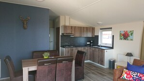 Eine kleine Küche mit Holzausstattung, einem eingebauten Herd und einem Fenster.