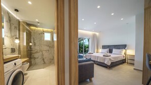 Ein modernes Schlafzimmer mit einem großen Bett, einem Nachttisch und Blick ins Freie.