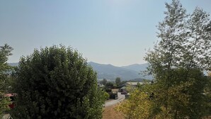 A clear sky with the sun shining, trees, and a distant view of mountains. - Charming & cosy T2, close to Casino Park and Spa (Argelès-Gazost)