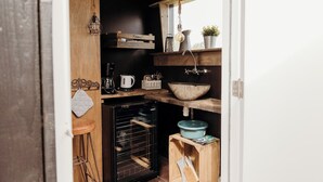 A compact kitchen with wooden shelves, a built-in oven, and a hanging light fixture. - Solglimt 2 pers holiday home with stunning views (Callantsoog)