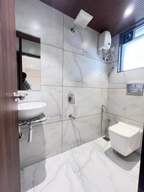 A bathroom with a white sink, a toilet, and a shower.