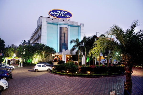A hotel with a prominent marquee sign, a parking area, and well-maintained landscaping.