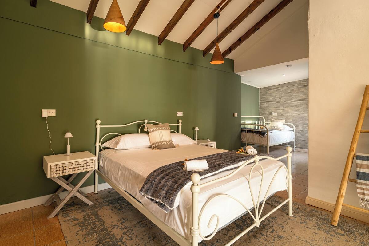 Een slaapkamer met een bed, nachtkastjes en een lamp.