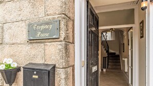 Entrada de un edificio de piedra con un letrero que dice "Egoney House".