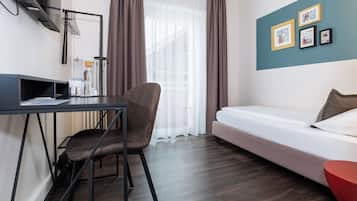 Une chambre d’hôtel moderne équipée d’un bureau, d’une chaise et d’un lit.