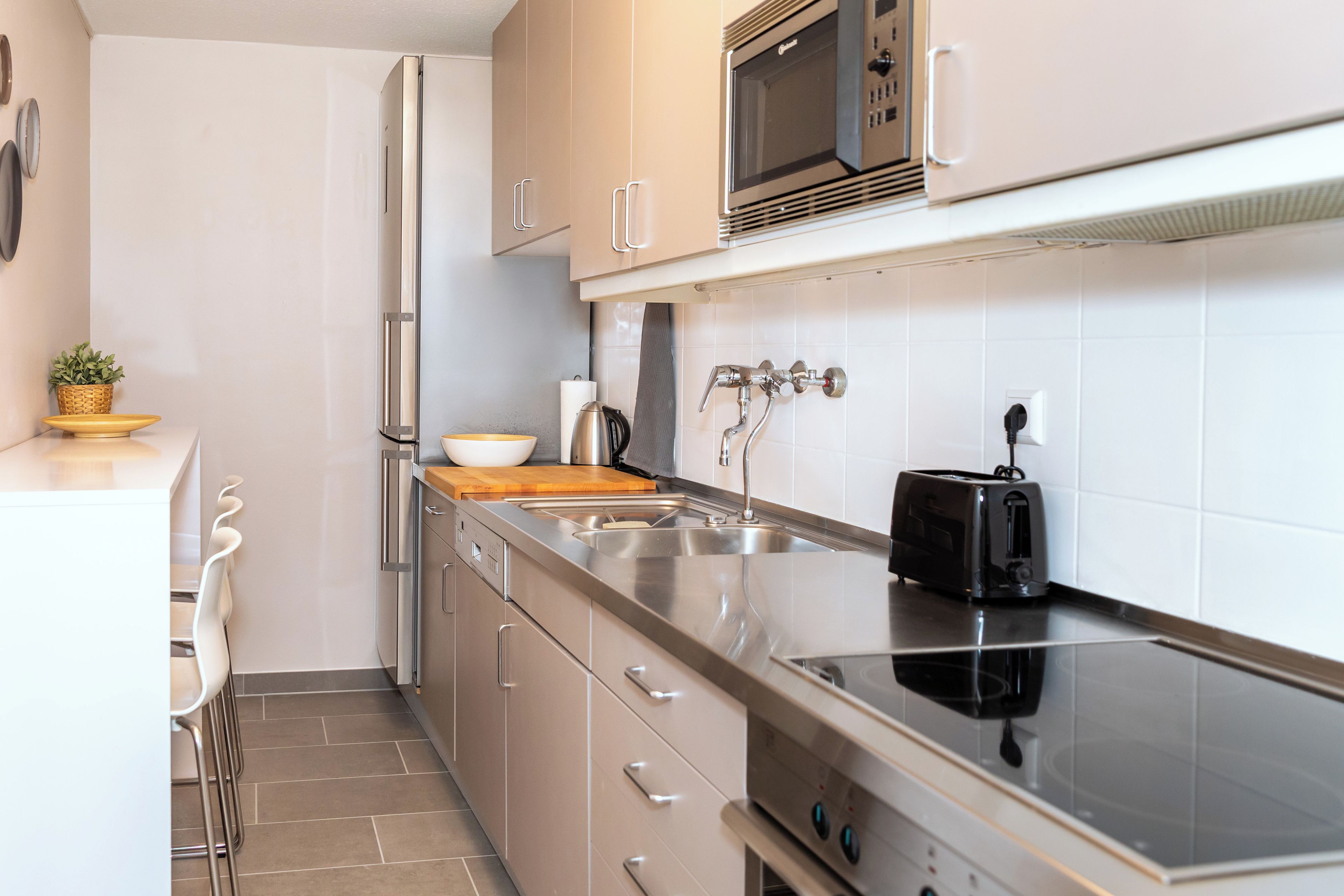 Eine moderne Küche mit Edelstahlgeräten, einer Spüle und einem Toaster.