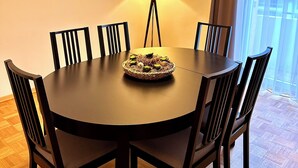 A round dining table with six chairs, a lamp, and a woven basket on the table. - Hotel Friedrichstraße  (Lampertheim)