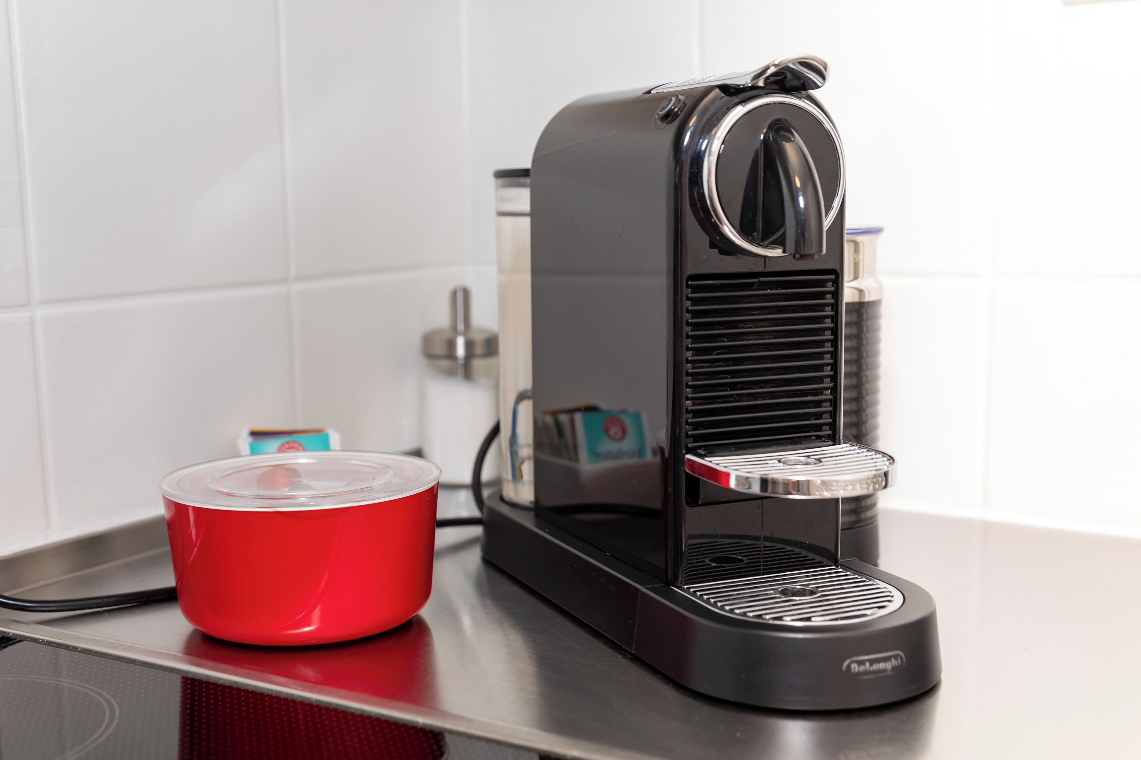 A coffee machine with a red cup on a countertop.