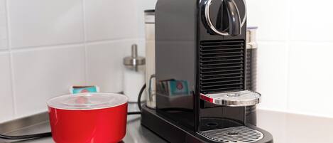 A coffee machine with a red cup on a countertop.