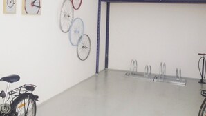 A room with a white wall, a blue-framed window, and a bicycle rack. - Hotel Friedrichstraße  (Lampertheim)