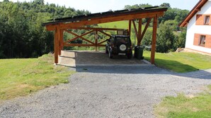 A covered parking area with a gravel path leading to a car. - Vacation home Dola II in Bohemian Paradise with pool (Mírová pod Kozákovem)