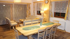 A cozy dining area with a wooden table, chairs, and a sofa. - Vacation home Dola II in Bohemian Paradise with pool (Mírová pod Kozákovem)