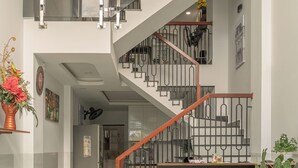A multi-level interior with a spiral staircase, a reception desk, and a potted plant. - Soul Station Studio Hotel II (Ho Chi Minh City)
