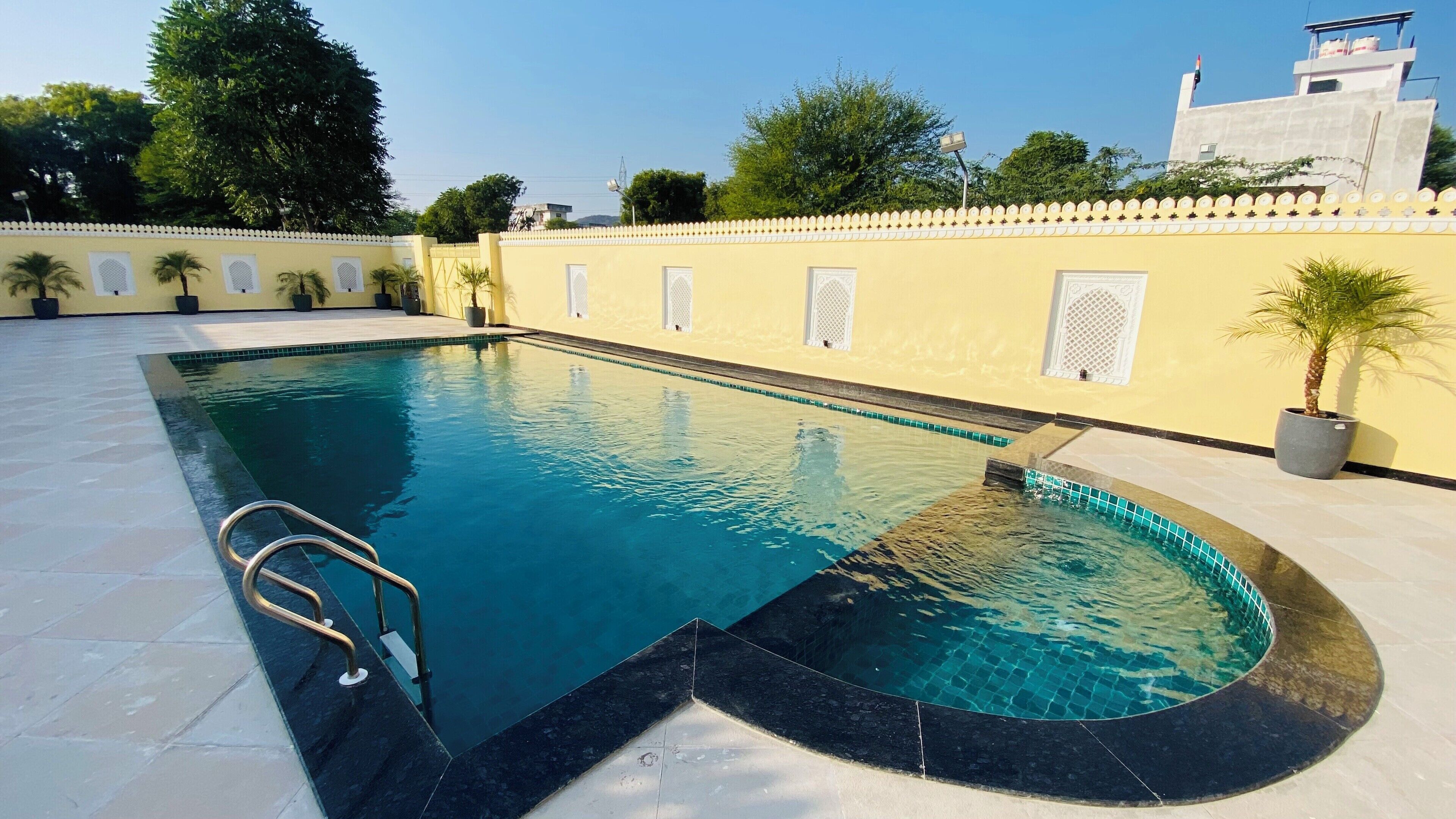 Una piscina rectangular con borde negro y escalera metálica.