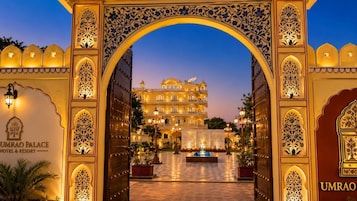 The entrance to Umrao Palace Hotel & Resort with ornate arches and a well-lit courtyard.