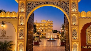 The entrance to Umrao Palace Hotel & Resort with ornate arches and a well-lit courtyard.