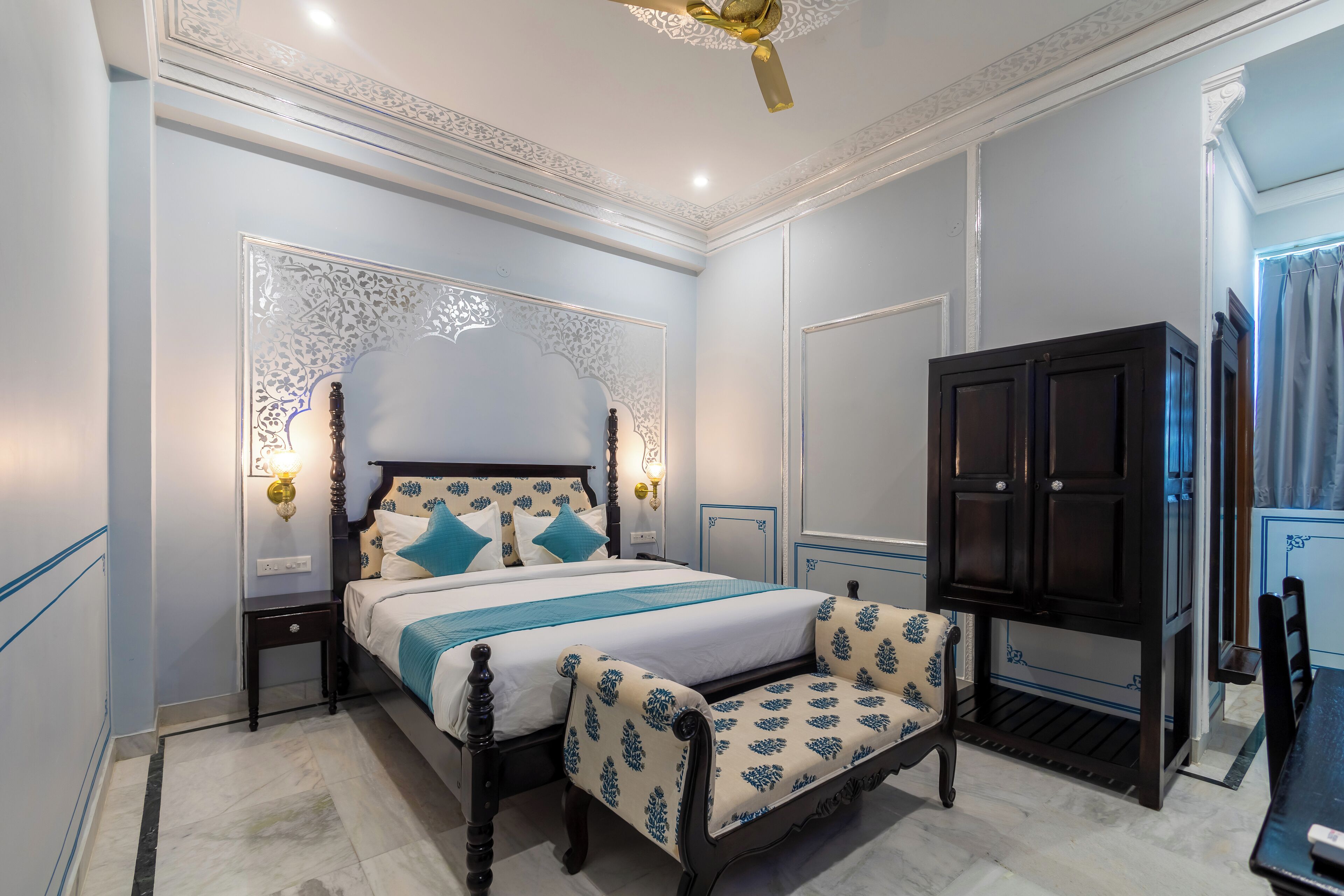A bedroom with a bed, nightstands, a wardrobe, and a chair.