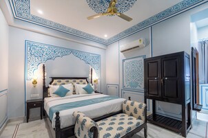 Un dormitorio con cama, mesitas de noche, armario y ventilador de techo.
