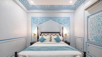 A bedroom with a large bed, ornate headboard, and decorative wall panels.