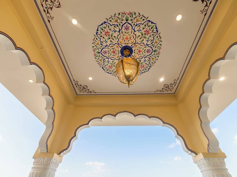 A ceiling with a floral pattern and a hanging light fixture.