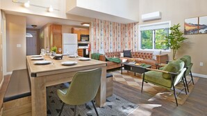 A modern living room with a dining area, a sofa, and a coffee table. - Cranmore home in North Conway|sleeps8|pet+ (Conway)