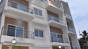 A multi-story hotel with balconies, large windows, and a sign indicating it is a hotel. - Hotel The Lake Castle Ranchi Jharkhand (Ranchi)