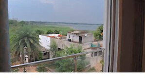 A view from a window overlooking a river, with buildings and greenery in the foreground. - Hotel The Lake Castle Ranchi Jharkhand (Ranchi)