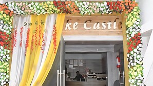 A hotel entrance with a yellow curtain, a wooden sign reading "ke Castle", and a reception desk. - Hotel The Lake Castle Ranchi Jharkhand (Ranchi)