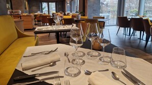 A dining area with tables set for a meal, including cutlery and wine glasses. - Hôtel Interlaken Lounge Bar & SPA (Xonrupt-Longemer)