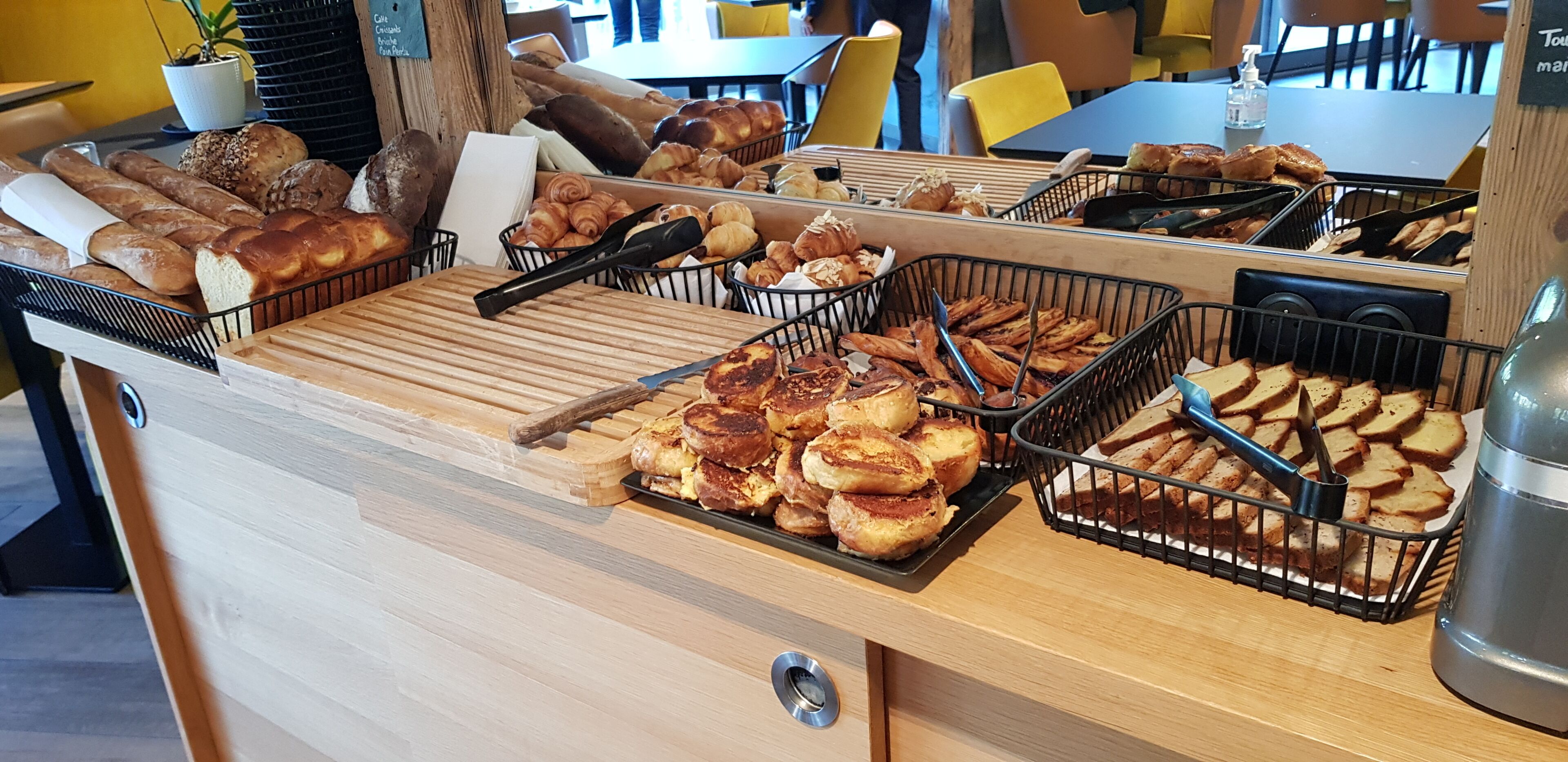 Ein Buffet mit verschiedenen Backwaren, darunter Brot, Gebäck und Muffins.