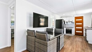 A modern kitchen with white cabinets, a black refrigerator, and a built-in oven. - Welcome to Cockatoos View (Point Vernon)