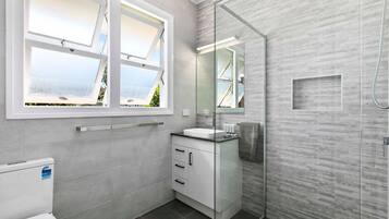 Un baño moderno con un ventanal grande, ducha e inodoro.