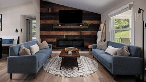 Ein modernes Wohnzimmer mit zwei Sofas, einem Couchtisch und einem Kamin.