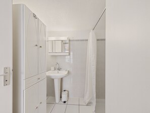 A bathroom with a sink, mirror, and shower curtain. - Stay for 5 with shared pool, terrace (Saint-Vincent-sur-Jard)