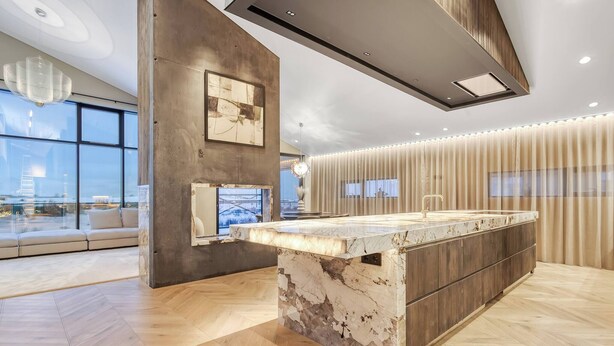 A modern kitchen with a marble island, large windows, and a city view. - Nordic Retreat by the Water Hot Tubs & Northern Lights (Garðabær)