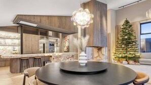 Una cucina moderna con isola centrale, sgabelli da bar e tavolo da pranzo con sedie.