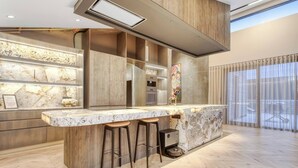 Una cucina moderna con un piano di lavoro in marmo, elementi in legno e forno a incasso.