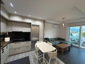 Un appartement moderne comprenant un coin cuisine, un espace repas et un salon avec un canapé et une table.
