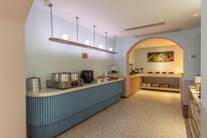Una cocina moderna con encimera azul, electrodomésticos de acero inoxidable y un arco decorativo.