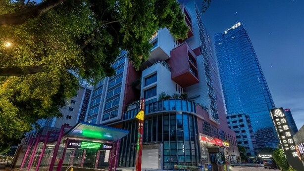 A modern hotel with a glass facade, a covered entrance, and a visible sign for a hotel named "Hotel". - Pazhou Poya International Hotel Canton Fair Complex Modiesha Metro Exit B Branch - Free Shuttle Bus to Canton Fair Complex During Canton Fair Period (Guangzhou)