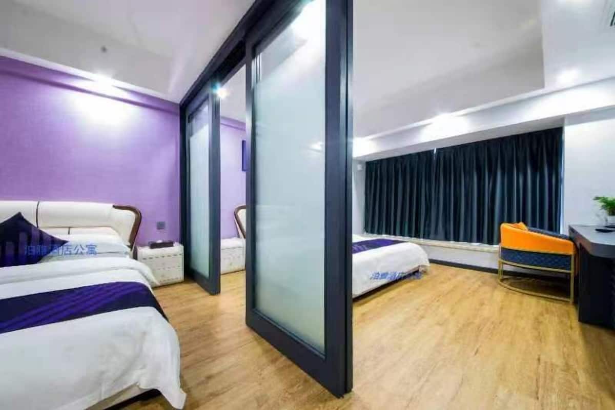 Ein Hotelzimmer mit zwei Betten, einem Schreibtisch und einem Stuhl.