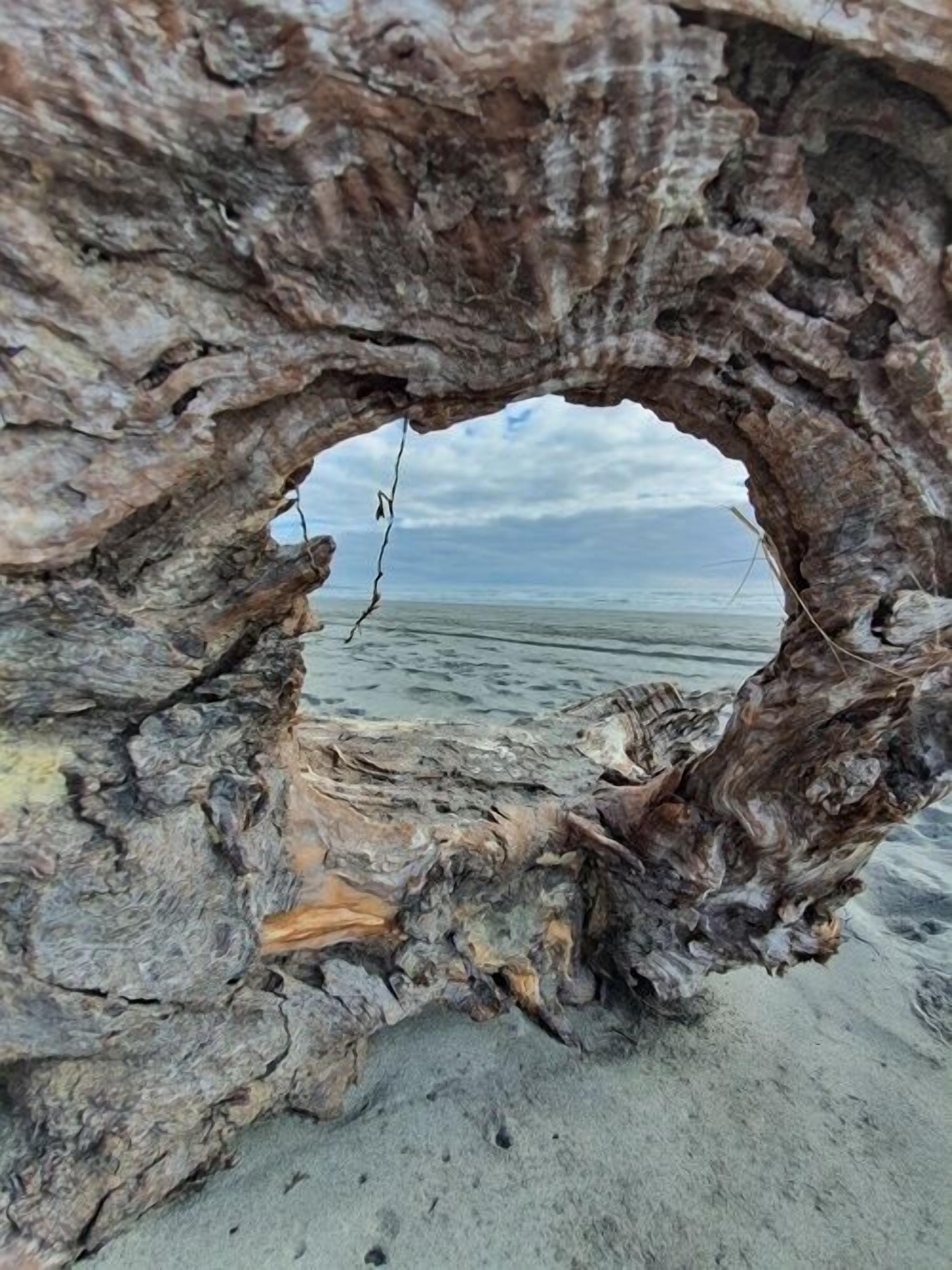 A natural rock formation with a hole through which the sea is visible.