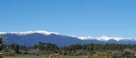Paisaje de montaña con picos nevados y un cielo azul despejado.